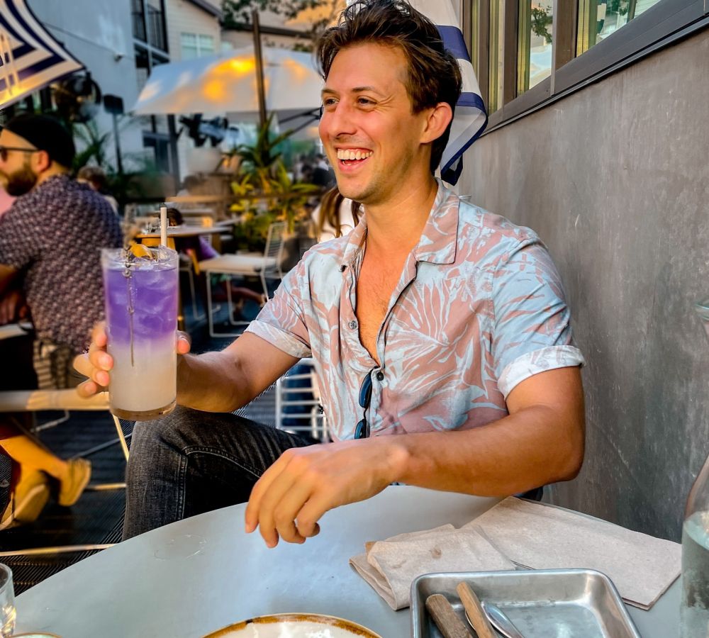 Young man at outdoor restaurant with a cocktail