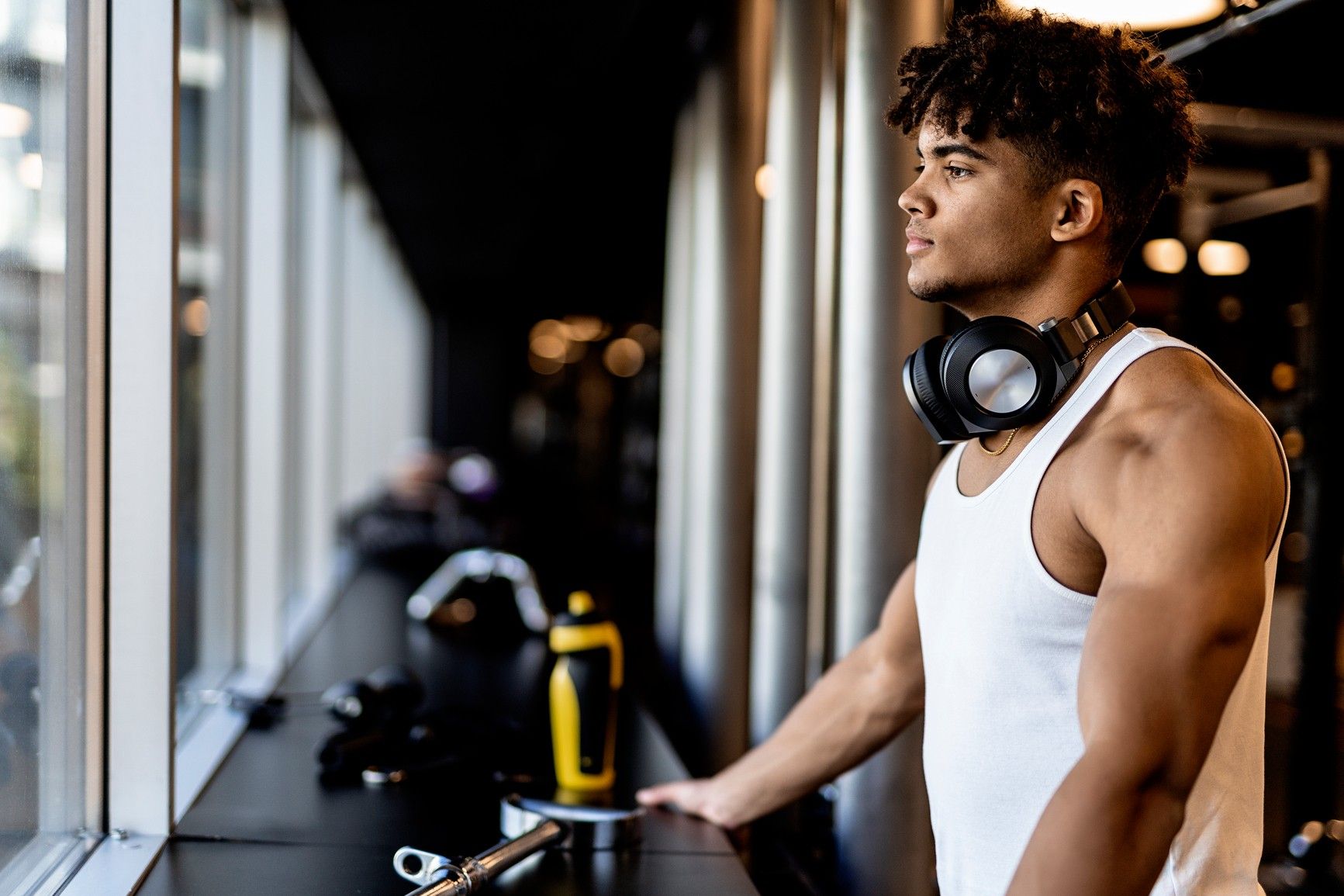 Young buff man in a gym with headphones