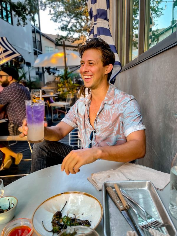 Young man at outdoor restaurant with a cocktail