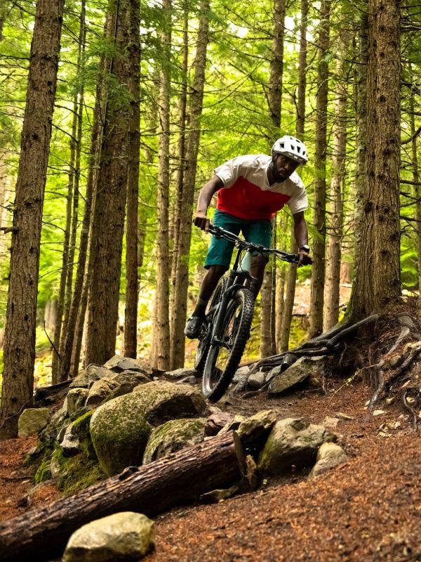 Young man mountain biking on a wooded trail