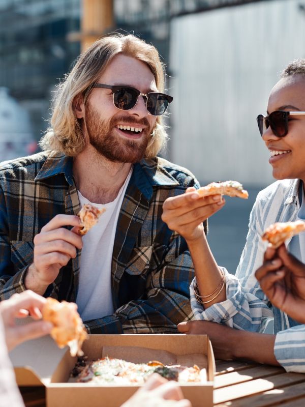 Alta Stone at the Gateway residents enjoying pizza together outside while wearing sunglasses